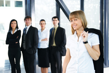 Five young business persons are standing as a team