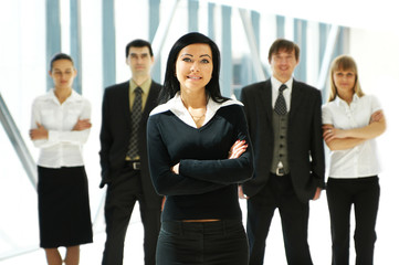 Five young business persons are standing as a team