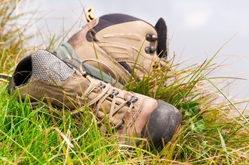 Old hiking boots close-up on green grass - 25437984
