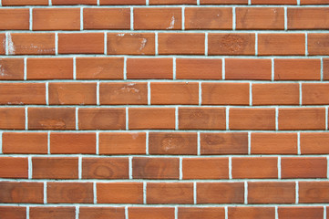 Old red brick wall background with uneven structure