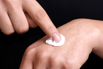 junge Frau cremt die Handfläche ein