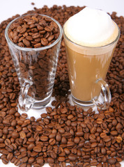 Caffe latte, glass of coffee beans surrounded by coffee beans
