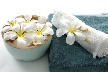 Bowl of frangipani and blue towel