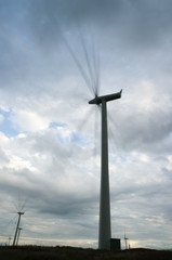Obraz premium Wind turbines spinning fast on windy day