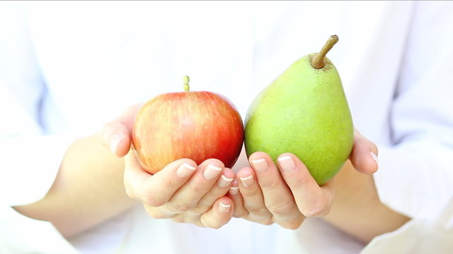 pear and apple in woman's hands