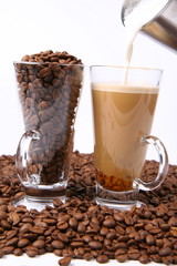 Making of caffe latte:glass of coffee, milk being poured into it
