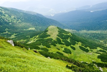 Fototapeta na wymiar green hill in a mountain valley