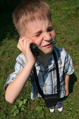 Young boy is phoning very grumpy