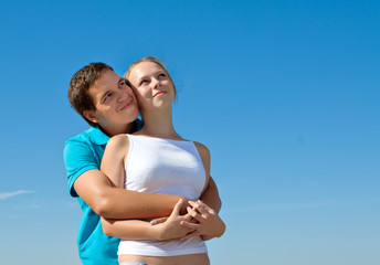 young couple embracing and looking in the sky