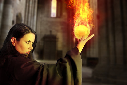 Young beautiful girl with fire sphere, sorcerer