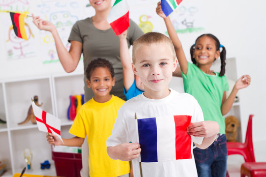 happy little french boy with diverse classmates in background