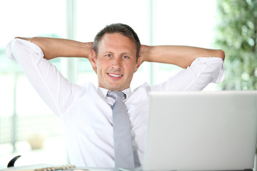 Businessman stretching arms in the office