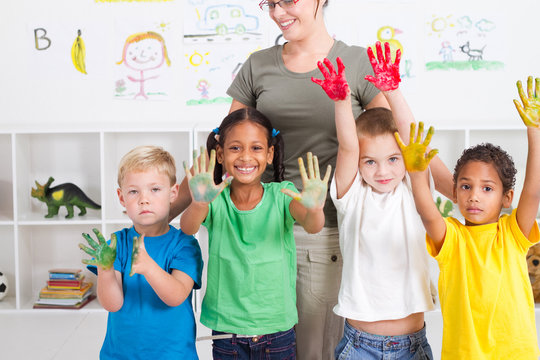 preschool kids with paint on hands with teacher