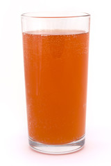 glass of fizzy orange over white