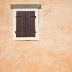 one window with dark wooden closed shutters