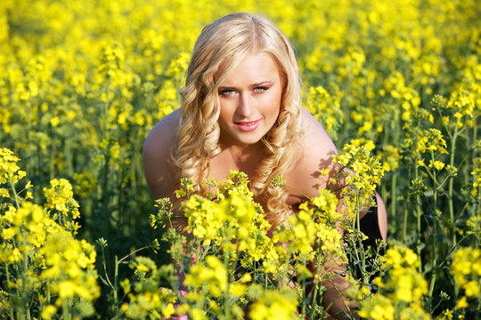 Beautiful young blonde woman in a field of wildflowers.