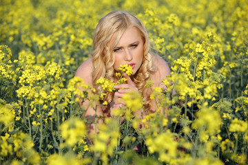 Beautiful young blonde woman in a field of wildflowers.