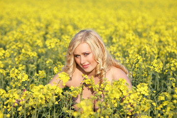 Fototapeta na wymiar Beautiful young blonde woman in a field of wildflowers.