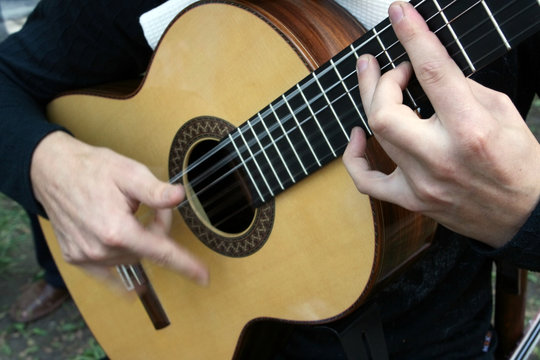 Man's hands plaing a guitar