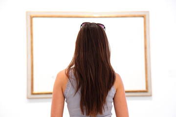 Woman looking at art painting in museum