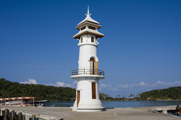 Fototapeta na wymiar White lighthouse in bay on Koh Chang island, Thailand.