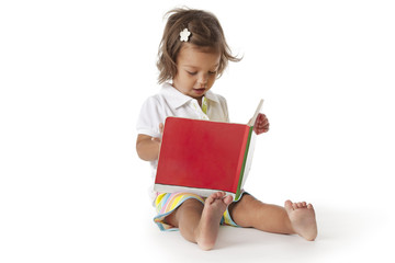 Toddler girl pretending to read a book