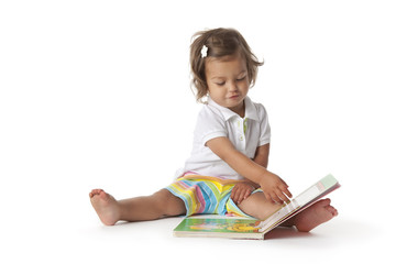 Toddler girl pretending to read a book