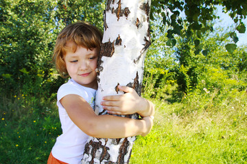 Care for nature - little girl embrace a tree