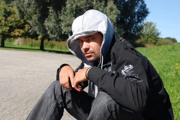 Portrait of adult guy in black windbreaker with hood