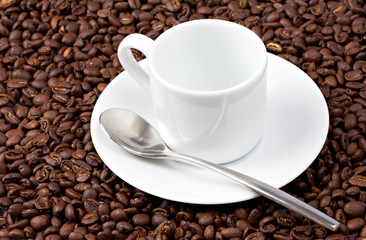 White espresso cup sat on coffee beans