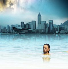 Man floating in water against backdrop of futuristic city