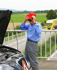Rentner mit Autopanne und Warndreieck auf der Autobahn