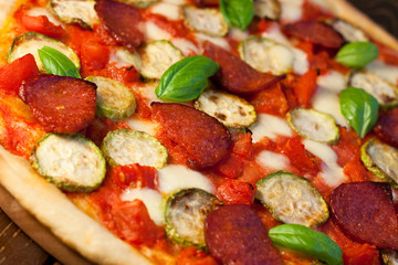 Pizza with courgettes, salami and tomatoes