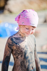 Little girl covered with mud