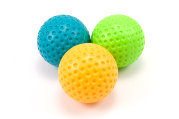 three colored plastic balls over a white background