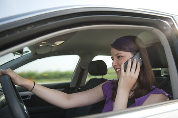 Fototapeta na wymiar Autofahrerin telefoniert während der Fahrt