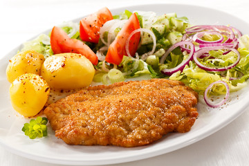 Fried pork chop with potatoes and vegetable salad