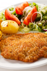 Fried pork chop with potatoes and vegetable salad