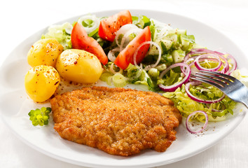 Fried pork chop with potatoes and vegetable salad