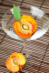 peach in the martini glass on a bamboo mat