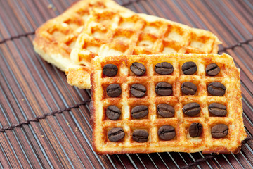 waffles and coffee beans on a bamboo mat