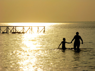 silhouette of mother and son in the sea