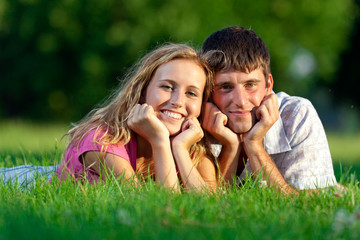 Couple resting on the grass in the park