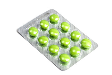Package of green pills isolated on white