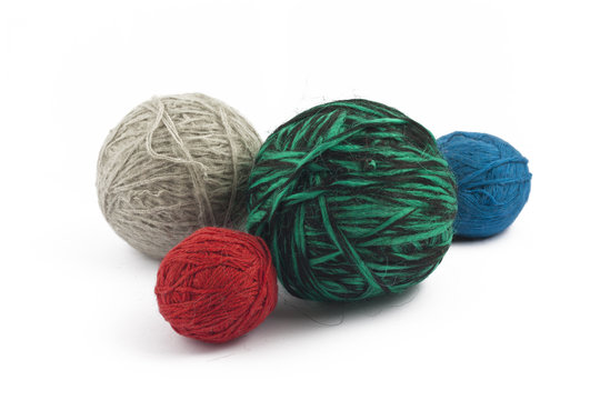 Four balls of wool on white background