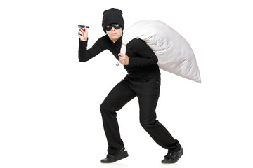 Robber with a bag and flashlight in hands isolated against white