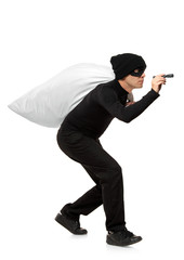 Thief carrying a bag and holding a torch isolated against white