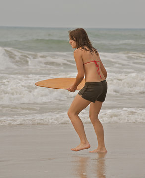 Young athletic girl skim boarding.