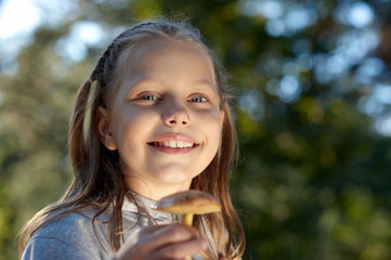 Attractive portrait of smiling little girl with mushroom