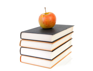 stack of books with apple over white background